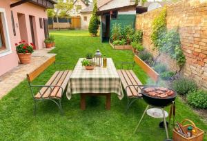 a table and chairs and a grill in a yard at Vienna Gateway - Self Check-In 24 - free parking in Bockfließ