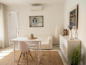 a white dining room with a white table and chairs at Basic Mansion Mandalina in Šibenik