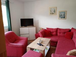 a living room with red couches and a tv at Apartment Barbara in Kulen Vakuf