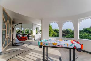 a living room with a table and a large window at Aara-boutique stay udaipur in Udaipur
