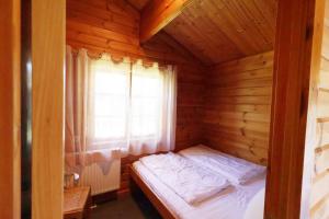 a small bed in a wooden room with a window at Ferienhaus Neckar 46 in Hayingen