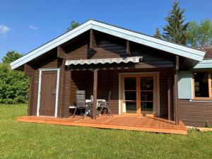 a small cabin with a deck with a table and chairs at Ferienhaus Neckar 43 in Hayingen