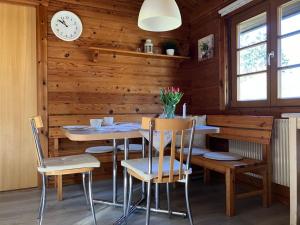 a dining room with a table and chairs and a clock at Ferienhaus Neckar 43 in Hayingen