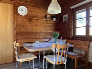 a dining room with a table and chairs and a clock at Ferienhaus Neckar 43 in Hayingen +19 photos