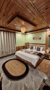 a bedroom with a large bed with a wooden ceiling at Saathi Stay & Cafe in Vashisht