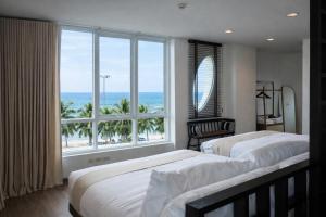 a bedroom with two beds and a large window at The Beach Bangsaen by Thanthita next to Wonnapa beach FREE DISNEY PLUS in Bangsaen +167 photos