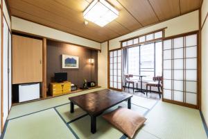 a living room with a table and a dining room at Yamatoya Honten Ryokan Osaka in Osaka