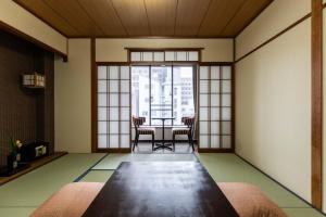 a room with a table and chairs in a room at Yamatoya Honten Ryokan Osaka in Osaka