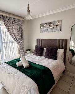 a bedroom with a large bed with a window at Charming Oasis in the East in Boksburg