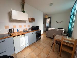 a kitchen with a sink and a table at Appartement familial centre et plage in Soulac-sur-Mer