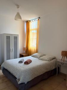 a bedroom with a bed and a window at Appartement familial centre et plage in Soulac-sur-Mer