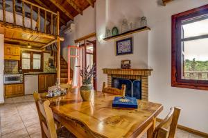 a kitchen with a wooden table and a fireplace at Manoli's House in Douliana