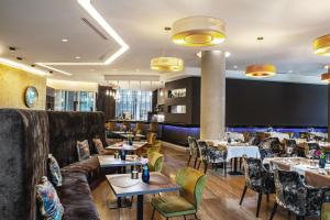 ein Restaurant mit Sofas, Tischen und Stühlen in der Unterkunft DoubleTree by Hilton Bratislava in Bratislava