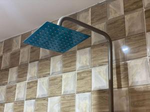 a shower with a blue light on a tiled wall at Dejuks Hotel & Resort in Akure