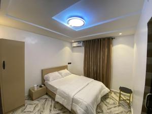 a hotel room with a bed and a blue ceiling at Dejuks Hotel & Resort in Akure