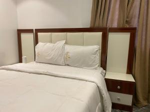a bed with white sheets and white pillows at Dejuks Hotel & Resort in Akure