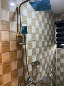 a shower in a bathroom with a tile wall at Dejuks Hotel & Resort in Akure