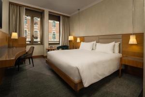 a hotel room with a large bed and a desk at Hilton Milan in Milan +190 photos