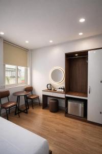 a room with a bed and a table and a mirror at Dreamora Signature Hotel in Hanoi +4 photos