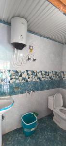 a bathroom with a sink and a toilet and a sink at Omji Niwas - Kalindi in Kharsālī