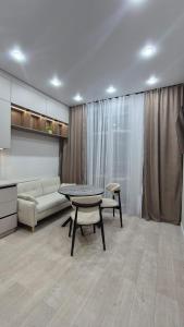 a living room with a table and a couch at Umayahouses ЖК Орбита in Karagandy