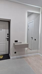 a white room with a mirror and a door at Umayahouses ЖК Орбита in Karagandy