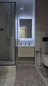 a bathroom with a sink and a mirror and a toilet at Umayahouses ЖК Орбита in Karagandy