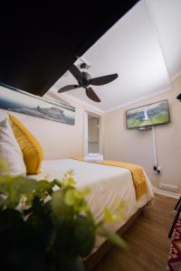 a bedroom with a bed with a ceiling fan at Faith, Hope & Love Self Catering in Port Elizabeth