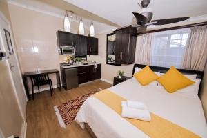 a bedroom with a large bed with yellow pillows at Faith, Hope & Love Self Catering in Port Elizabeth
