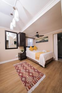 a bedroom with a bed and a rug at Faith, Hope & Love Self Catering in Port Elizabeth