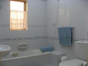 Baño blanco con aseo y lavamanos en Valletta Gateway Maisonette en La Valeta