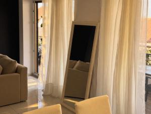 a mirror in a living room with a chair and a couch at BASIC MANSION plus with swimming pool & free parking in Šibenik