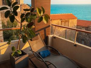 a balcony with a chair and a potted plant at BASIC MANSION plus with swimming pool & free parking in Šibenik