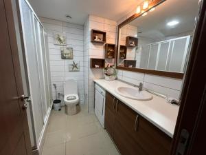 a bathroom with a sink and a toilet and a mirror at Premium Airport Residence 2 in Baku +15 photos