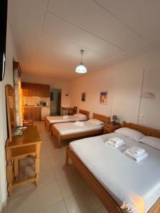 a room with three beds and a kitchen at ART STUDIO APARTMENTS in Órmos Aiyialís