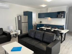 a living room with a couch and a kitchen at Jurien Beachfront Chalets in Jurien Bay