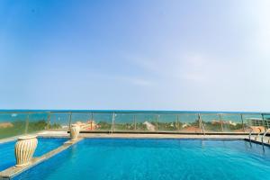 a swimming pool with a view of the ocean at Palette Muine Boutique Hotel Near Mui Ne Beach in Mui Ne