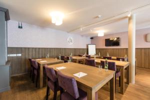 einen Konferenzraum mit Holztischen und -stühlen in der Unterkunft Hotel - La Grande Cure in Marcourt