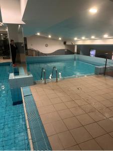 a swimming pool with a man standing next to it at Łucka 15 Sweet Home in Warsaw