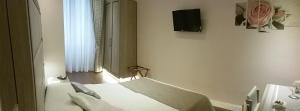 ローマにあるDomus Claraのベッドルーム1室(ベッド1台、壁掛けテレビ付)