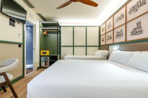 ein Schlafzimmer mit einem großen weißen Bett und einem Stuhl in der Unterkunft Petit Palace Tamarises in Getxo
