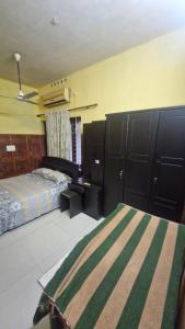 a bedroom with a bed and a desk and cabinets at Yara Homes in Cochin +9 photos