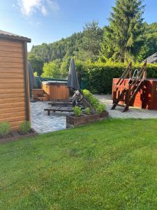 a patio with tables and umbrellas in a yard at Pokoje Marta in Międzybrodzie Bialskie