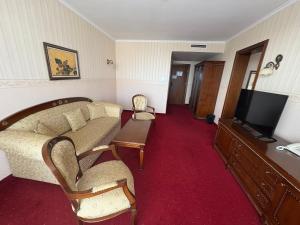 a living room with a couch and a tv at Motel Hanat in Saints Constantine and Helena