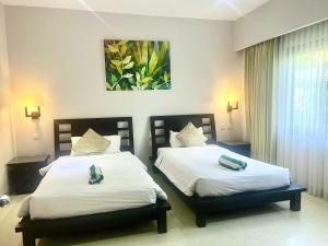 a bedroom with two beds with white sheets at Peninsula Villa in Nusa Dua +9 photos