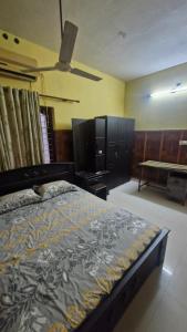 a bedroom with a bed and a table in it at Yara Homes in Cochin