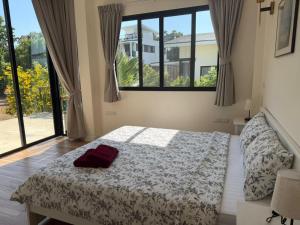 a bedroom with a bed and a large window at Phangan Sky Villa in Ban Madua Wan