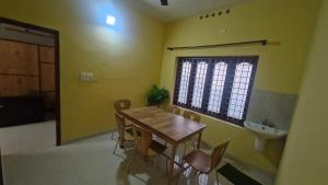 a dining room with a table and chairs and a sink at Yara Homes in Cochin