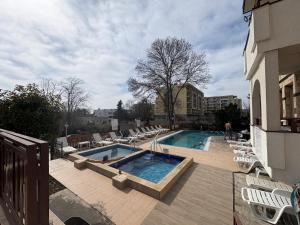 a swimming pool with lounge chairs next to a building at Motel Hanat in Saints Constantine and Helena