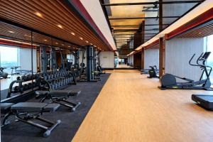 a gym with a row of treadmills and machines at Trans Hotel Jakarta in Cibubur